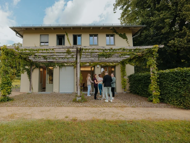 Pfingstberghaus Potsdam Eine Gruppe von Personen steht auf der Terrasse des Pfingstberghaus in Potsdam.