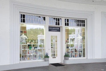 YouCaseStore Eingang eines modernen Geschäfts mit großer Fensterfront und stilvoll dekoriertem Schaufenster.