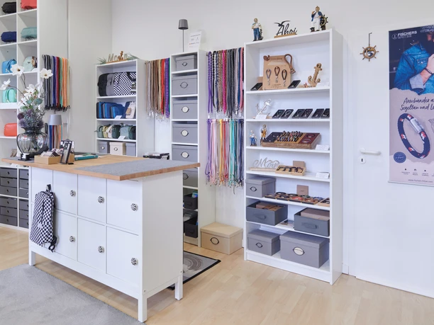 YouCaseStore Ein Laden mit hellen Regalen, Accessoires und einer Ladentheke. Vielseitige Auswahl an Produkten.