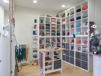 YouCaseStore Ein liebevoll gestalteter Laden mit Regalen voller bunter Taschen und einigen Regenschirmen.