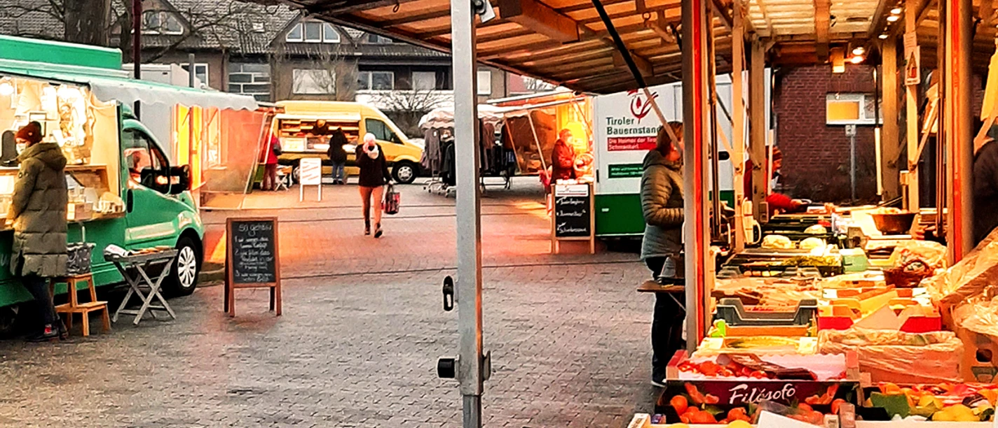 Rahdener Wochenmarkt Obst- und Gemüsestände auf einem typischen Wochenmarkt bei Tageslicht mit Besuchern.