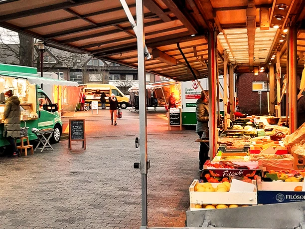 Rahdener Wochenmarkt Obst- und Gemüsestände auf einem typischen Wochenmarkt bei Tageslicht mit Besuchern.