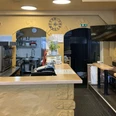 Pizzeria Don Calzone Hövelhof Innenansicht der Pizzeria mit Theke, Pizzaöfen, Stapel von Pizzakartons und Tischen auf der rechten Seite.