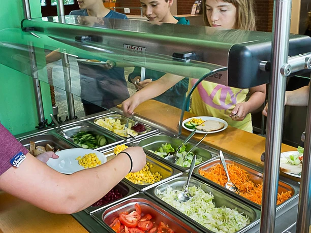 Jugendherberge Lindlar Jugendliche bedienen sich an einem bunten Salatbuffet mit verschiedenen frischen Zutaten und Gemüse.