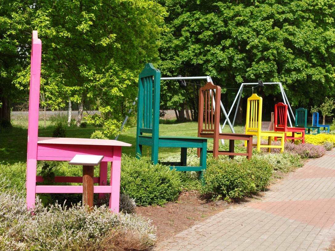 Reihe bunter Stühle am Wegesrand