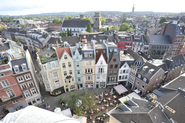 Öffentliche Architekt(o)ur Führung in Aachen Blick von oben auf einen Teil des Münsterplatzes mit Außengastronomie und schmalen Reihenhäusern mit spitzen Dächern.
