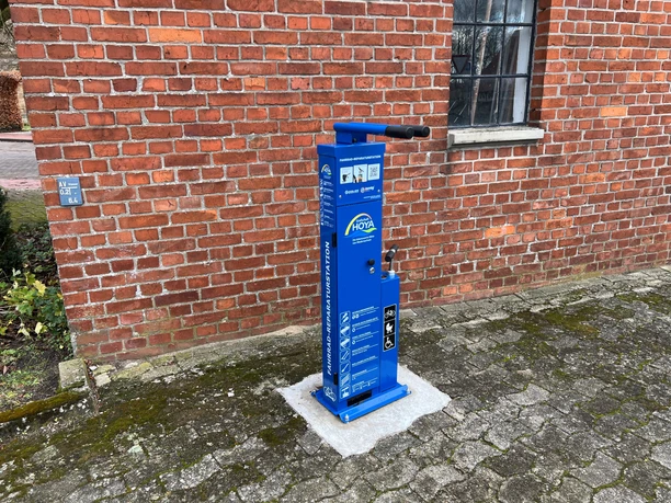 Radstation Bücken Fahrrad-Service-Station vor einer Backsteinmauer in der Gemeinde Bücken, bereit zur Fahrradreparatur.