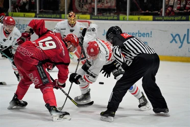 Eishockeyspiel zwischen den Herford Ice Dragons und einem Gegner; Spieler in Aktion beim Puckeinwurf.