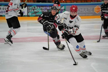 Herford-Ice-Dragons-Spiel- 4-Jana-Hemmelmann.jpg Zwei Eishockeyspieler in Bewegung, vertieft im Spielgeschehen auf einer Eisfläche während eines Matches.