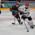 Herford-Ice-Dragons-Spiel- 4-Jana-Hemmelmann.jpg Zwei Eishockeyspieler in Bewegung, vertieft im Spielgeschehen auf einer Eisfläche während eines Matches.