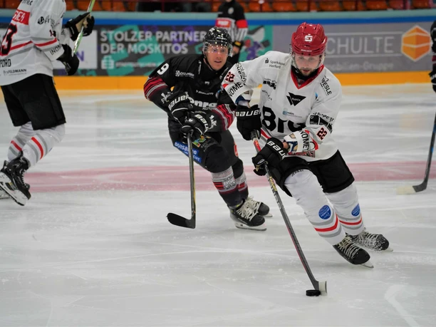 Herford-Ice-Dragons-Spiel- 4-Jana-Hemmelmann.jpg Zwei Eishockeyspieler in Bewegung, vertieft im Spielgeschehen auf einer Eisfläche während eines Matches.