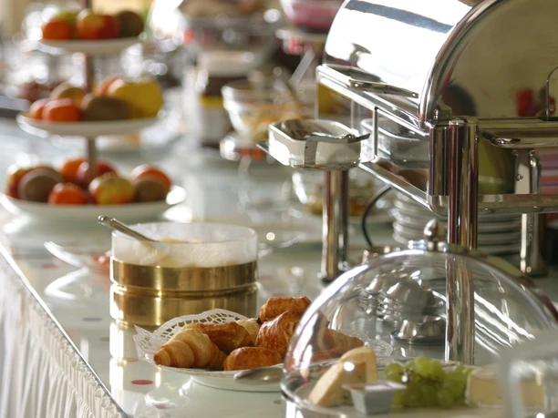 Ein reichhaltiges Frühstücksbuffet mit frischen Croissants, Obst und weiteren Köstlichkeiten erwartet Gäste.