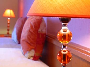 Detailaufnahme eines Hotelzimmers mit stimmungsvoller Beleuchtung und dekorativen Glaslampen.