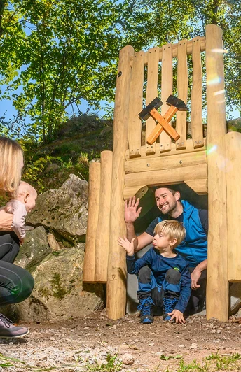 Nachgebauter Stollen am Bergbaupfad mit einer Familie am Eingang