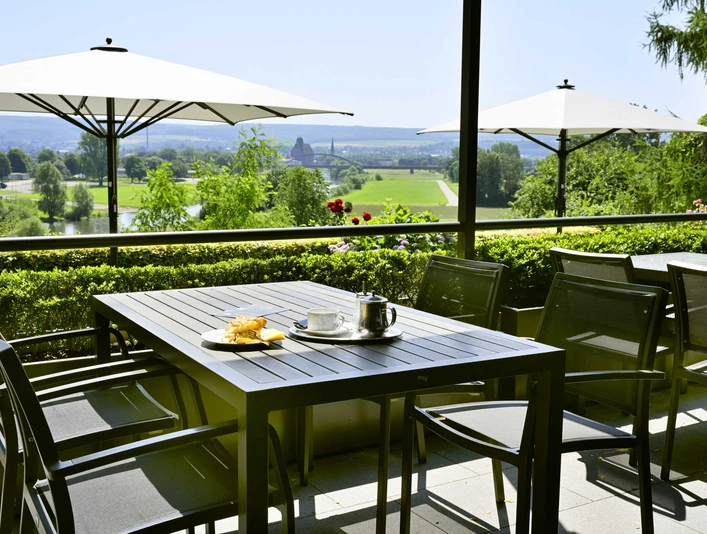 Kiekenstein-2024-219_Restaurant.jpg Gastronomie Außenterrasse mit Tischen, Stühlen und Sonnenschirmen, mit Blick über die Weser