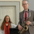 Fenstermusik Alexander Grötzner, Anna-Maria Pfotenhauer Rechte privat.JPG Saxophonist Alexander Grötzner und Pianistin Anna-Maria Pfotenhauer vor einem Klavier in einem Raum.