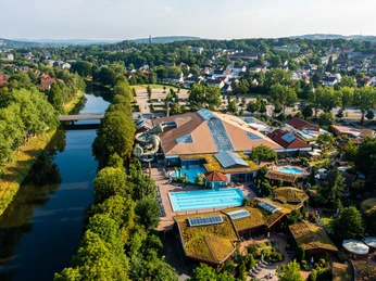 herford-h2o-teutoburger-wald-tourismus-h-tornow-010-jpg.jpg Luftaufnahme zeigt das Freizeitbad H2O in Herford mit Außenbecken, umgeben von Bäumen und Stadtlandschaft.