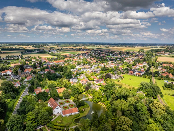 Preußisch-Oldendorf-Kurpark Bad Holzhausen Luftaufnahme des Kurparks Bad Holzhausen mit grünen Wiesen, einem Teich und umliegenden Gebäuden.