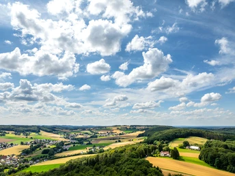 Weite Landschaft mit Feldern und Wäldern unter blauem Himmel mit Wolken, Preußisch-Oldendorf, Bad Holzhausen.