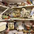 Spielzeugmuseum Historisches Spielzeugmuseum mit Puppen, Teddybären und Holzpferdchen auf Regalen bestückt.