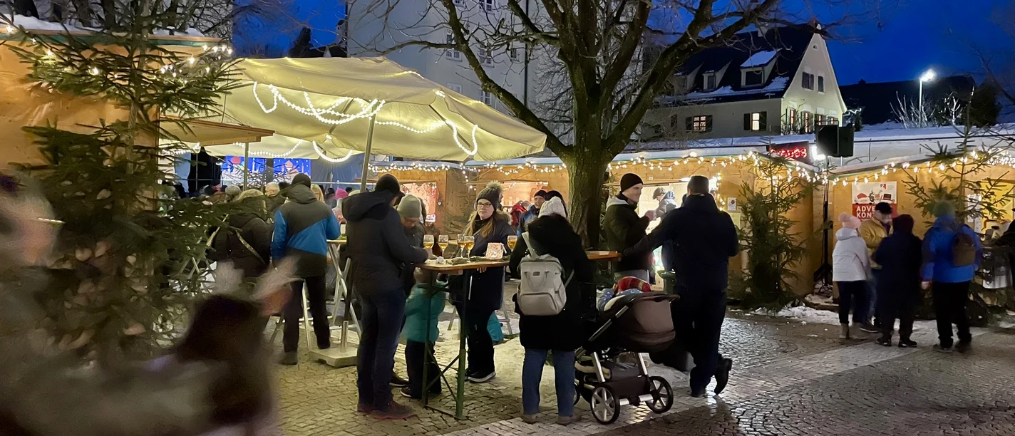Günzburger Altstadtweihnacht Menschen genießen eine winterliche Atmosphäre auf einem gemütlichen Weihnachtsmarkt in der Altstadt.