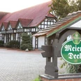 Traditionelles Fachwerkhaus mit rotem Ziegeldach in Stemwede, Schild zeigt Schriftzug "Meier's Deele".