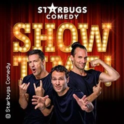 Drei Künstler von Starbugs Comedy posieren gestikulierend vor einem Hintergrund mit Leuchtschrift.