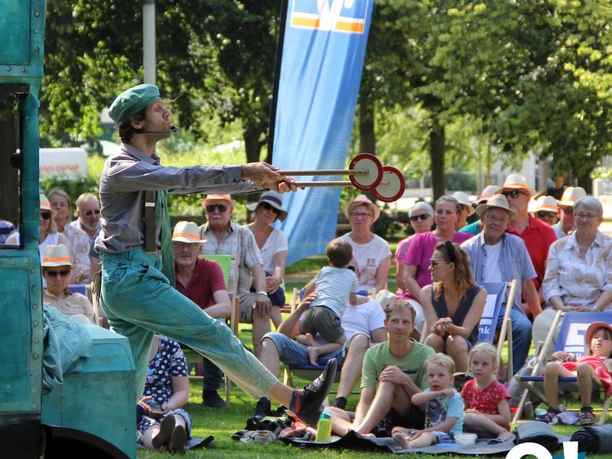 Herford-Mein Sommer Meine Stadt-Pro Herford GmbH.jpg Ein Jongleur in Aktion, umgeben von einem aufmerksamen Sommerpublikum im Park.