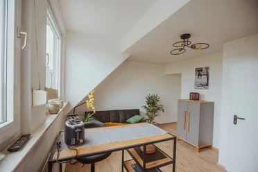 FeWo Hille Krysiak Moderne Ferienwohnung mit stilvoller Einrichtung, hellen Wänden und komfortablen Sitzmöglichkeiten.
