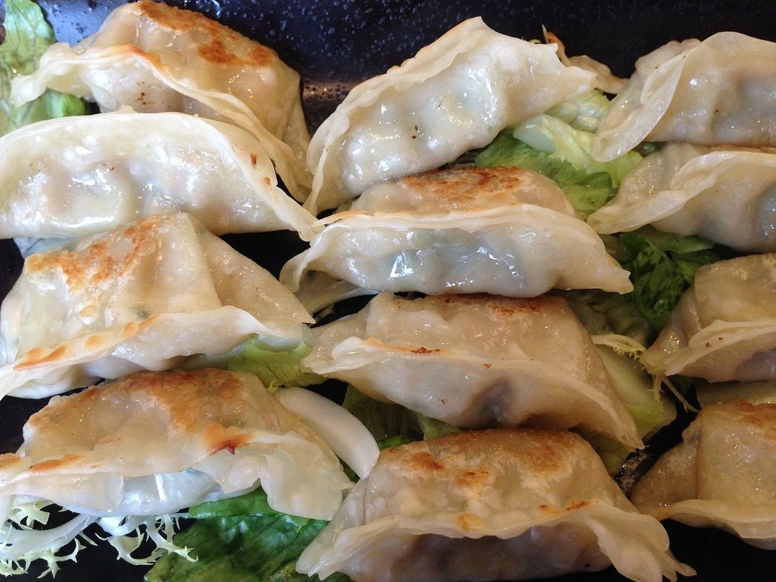 dumplings_Pixabay.jpg Dumplings liegen nebeneinander auf Salatblättern.