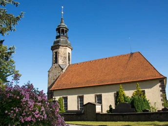 Kirche Erholungsort Waltersdorf blühender Rosenstrauch vorn