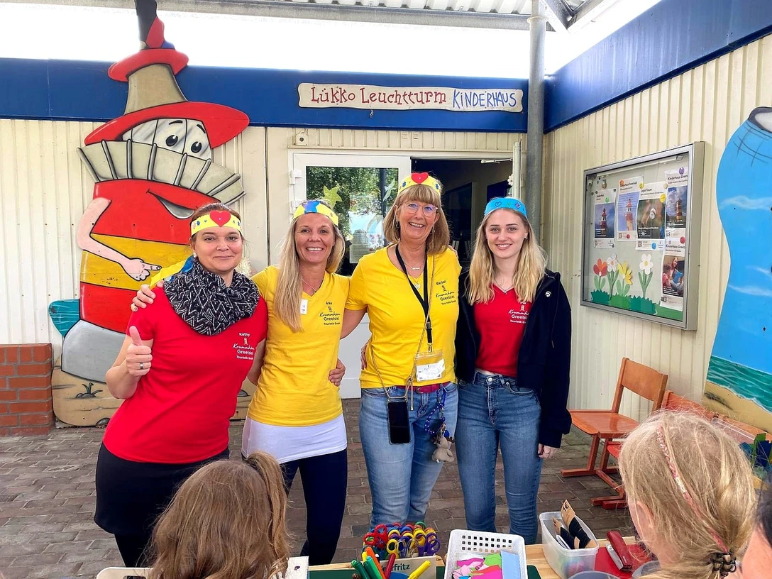Kinderhaus-Team Vier Mitarbeiterinnen des Lükko-Leuchtturm-Kinderhauses stehen lachend vor dem Eingang mit Kindern.Four employees of the Lükko lighthouse children's home stand laughing in front of the entrance with children.Fire medarbejdere fra Lükko fyrs børnecenter står og griner foran indgangen med børn.Vier medewerkers van het Lükko vuurtorenkindercentrum staan lachend met kinderen voor de ingang.