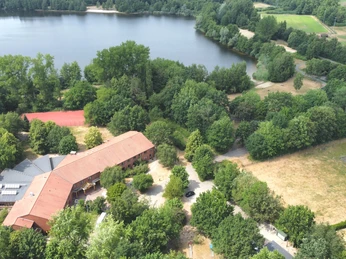 Familienzeit CR Jugendherberge Lingen.jpg Luftaufnahme der Jugendherberge Lingen am See, umgeben von Bäumen, Sportanlagen und Wiesen.