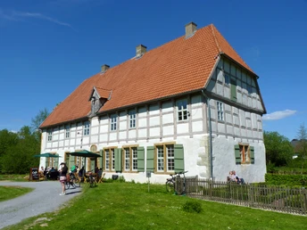 Werburg-Herrenhaus_bshf.jpg Das historische Fachwerkgebäude mit roten Dachziegeln befindet sich in einer grünen Landschaft.