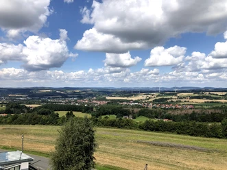 Blick auf Bösingfeld Bösingfeld und seine malerische Umgebung liegen eingebettet zwischen sanften Hügeln unter blauem Himmel.