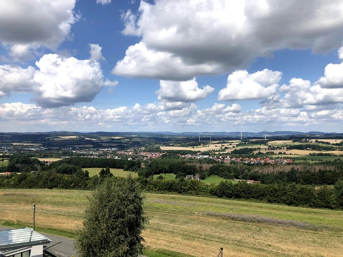 Blick auf Bösingfeld Bösingfeld und seine malerische Umgebung liegen eingebettet zwischen sanften Hügeln unter blauem Himmel.