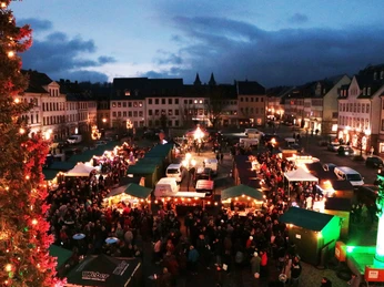 Rochlitzer Weihnachtsmarkt - Weihnachten in der Region Leipzig Blick auf die Verkaufstände des hell erleuchteten Weihnachtsmarkts auf dem Marktplatz in Rochlitz am Abend