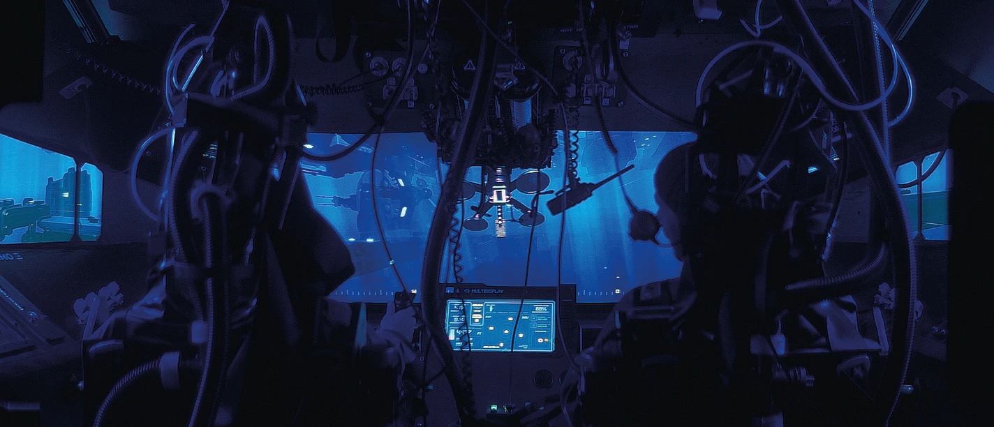NEMO3 Blick in das Cockpit eines U-Boots mit zahlreichen Kabeln und Bildschirmen, die in blauem Licht leuchten, und einem Fenster mit Unterwasseransicht.