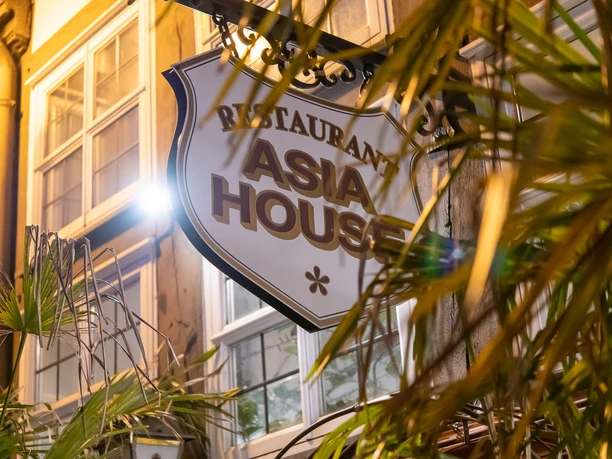 Restaurant Asia House" sign on the exterior facade of a half-timbered house.