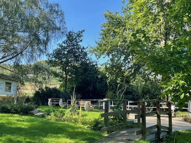 Godelheim-Tretbeckenanlage_schattiges Plätzchen.jpg Grünanlage mit kleiner Brücke