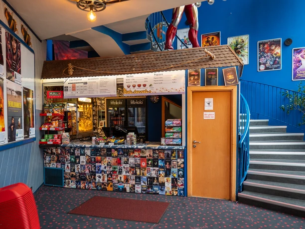 Filmpalast: Kasse Kassenbereich des Kinos, überall hängen Filmplakate.