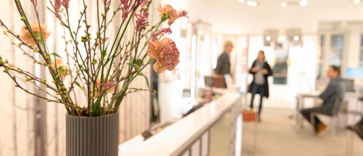 Innenraum eines Optikergeschäfts mit Blumenstrauß im Vordergrund