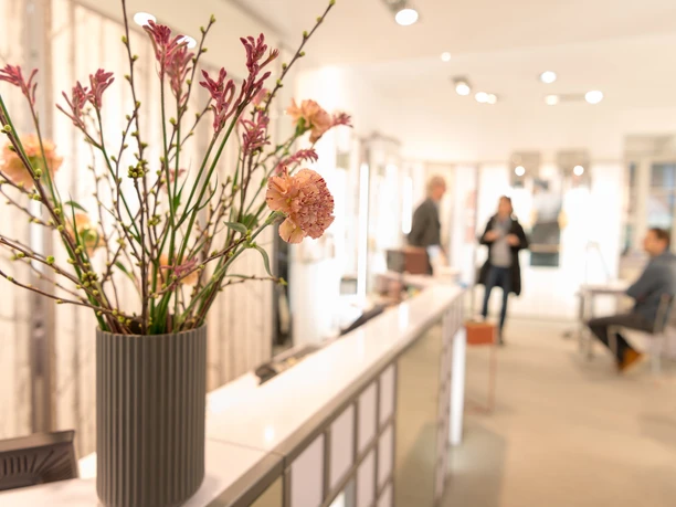 Innenraum eines Optikergeschäfts mit Blumenstrauß im Vordergrund