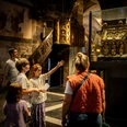 Eine Gruppe von Kindern betrachtet im Aachener Dom den Marienschrein in einem Glaskasten.