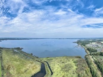 Dümmer-See Weitläufige Seelandschaft mit umliegenden Wiesen und Wäldern unter einem blauen Himmel.Extensive lake landscape with surrounding meadows and forests under a blue sky.Stort sølandskab med omkringliggende enge og skove under en blå himmel.Uitgestrekt merenlandschap met omliggende weiden en bossen onder een blauwe hemel.