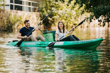 Deux personnes sont assises dans un Green Kayak du Stadthafen Leipzig sur le canal de Leipzig et peuvent accessoirement ramasser des déchets, Leipzig, ville d'eau, durabilité