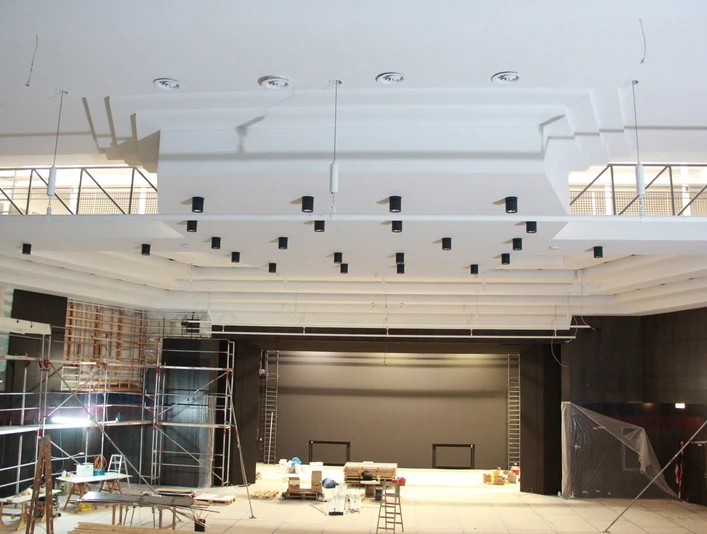 Innenansicht einer im Bau befindlichen Stadthalle mit modernem Bühnenbereich und Gerüsten.