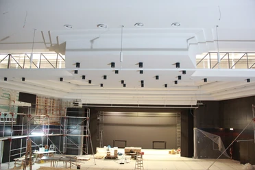 Stadthalle.JPG Innenansicht einer im Bau befindlichen Stadthalle mit modernem Bühnenbereich und Gerüsten.