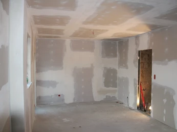 Büro.JPG Leerer Raum im Rohbauzustand mit grauer Betonboden und freiliegenden Wänden ohne Verkleidung.