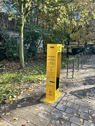 Radservicestation Bielefeld "Wolf-Otto" Gelbe Fahrradservice-Station von ADAC in herbstlicher Umgebung mit Bäumen und Laub auf dem Boden.